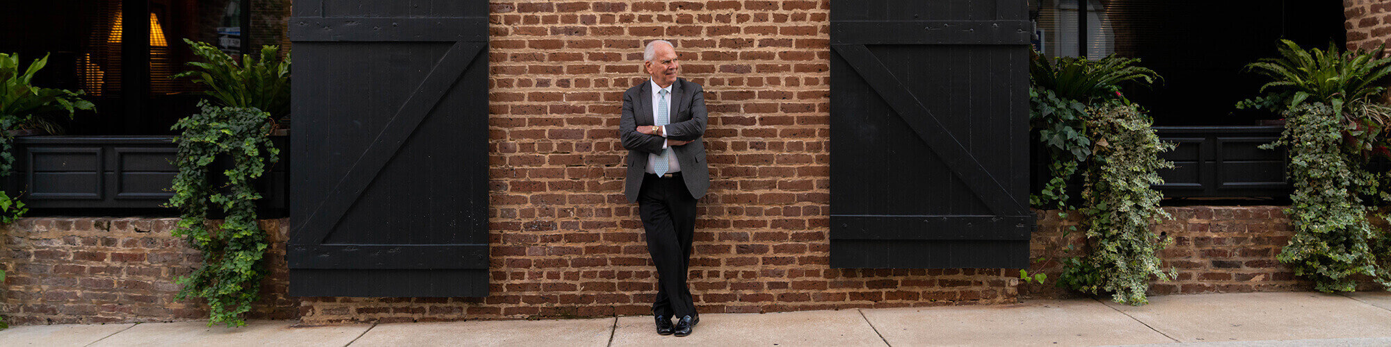Man standing against brick wall